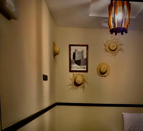 a room with some straw hats on the wall at Hôtel Riad Atlas Dades in Boumalne