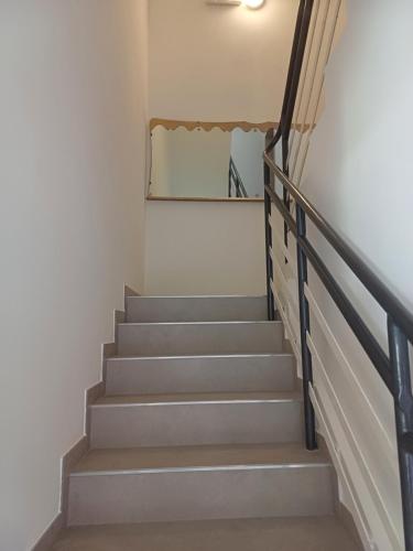 a staircase in a house with a mirror on the wall at Hotel Flora in Cesenatico