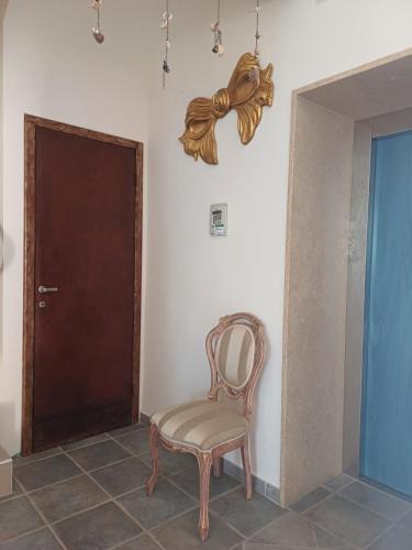 a chair sitting in a room with a door at Hotel Flora in Cesenatico