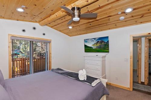 ビッグ・ベア・シティにあるStylish Elysian Big Bear Cabin w Enclosed backyardのベッドと天井扇風機のある寝室