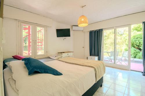 1 dormitorio con 1 cama grande y TV en CASA infinita en Punta del Este