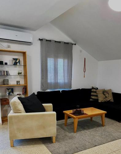a living room with a couch and a coffee table at Casa Gilboa Nirvana Suite נופש בגלבוע in Gan Ner