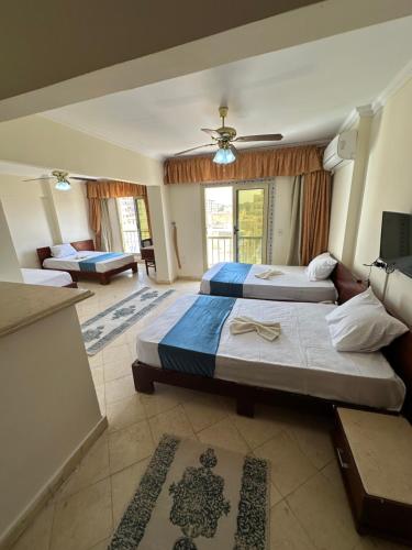 bianco Hotel & Suites في مرسى مطروح: غرفة نوم بسريرين وصالة جلوس