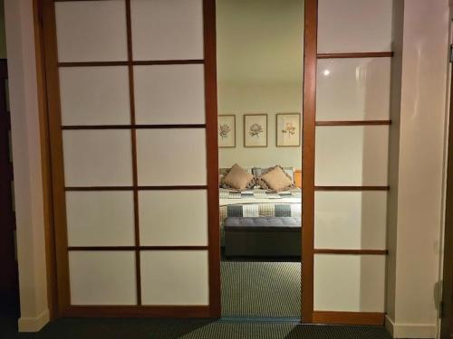 a room with a bedroom with a bed and a door at Cloud Nine Apartment @ Tamar Ridge in Grindelwald