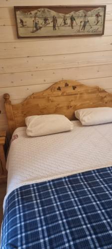 un lit avec une tête de lit en bois dans une chambre dans l'établissement VARS LES CLAUX, à Vars