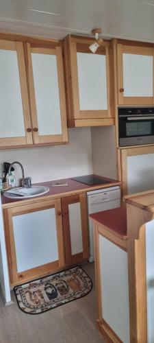 une cuisine avec des armoires en bois et un évier dans l'établissement VARS LES CLAUX, à Vars