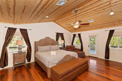 a bedroom with a bed and a couch and wooden ceilings at Minnow's Big Bear Estate 1.5 Acres W Game Room in Big Bear City