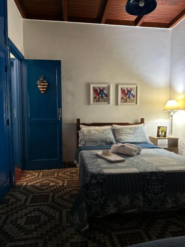 - une chambre avec une porte bleue et un lit dans l'établissement Hostel 040, à Itaipava