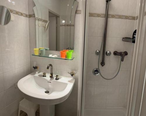 a white bathroom with a sink and a shower at 98, Bergblick, 2 Schlafzimmer, Dusche , WC, Küche, Wohnzimmer in Bad Reichenhall