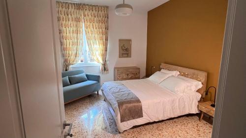 a bedroom with a bed and a blue couch at Diana Home - Rooms and Suite in Caserta