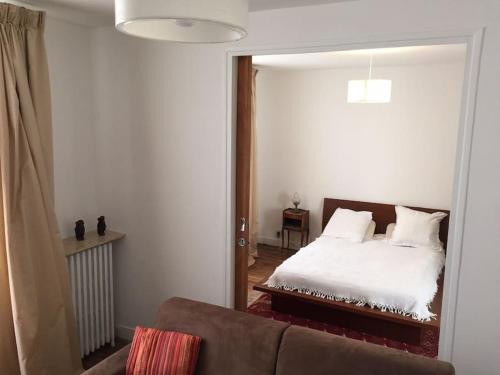 - un salon avec un lit et un miroir dans l'établissement Charmant Appt 2/4 pers Quartier Père Lachaise, à Paris
