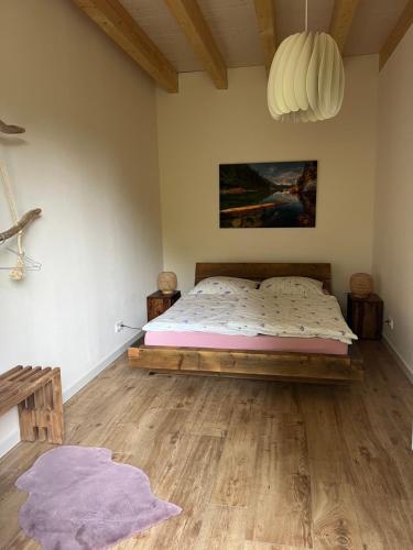 a bedroom with a bed and a wooden floor at Ferienhaus Ulme in Naunhof Leipziger Neuseenland in Köhra