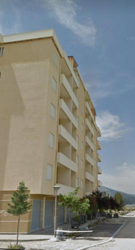 a large apartment building with trees in front of it at Sea & Sun Apartment Orikum in Orikum