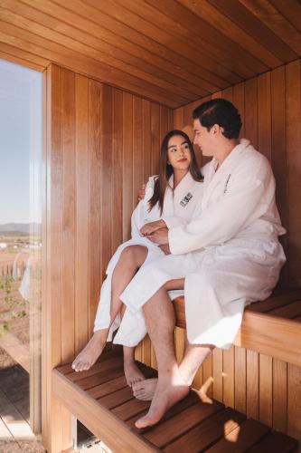 a man and a woman sitting in a sauna at Bajo Estrellas Hotel Contemporáneo in Valle de Guadalupe