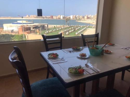 una mesa con platos de comida y una gran ventana en The View Aqua Park, en Marsa Matruh