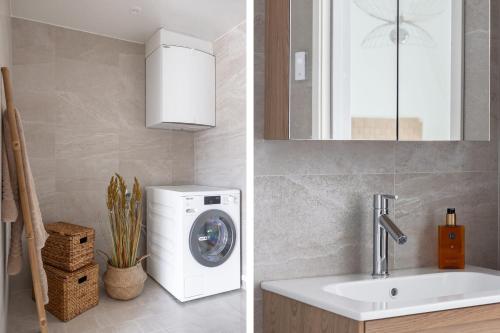 a bathroom with a washing machine and a sink at The Oak - Ekerum Öland in Borgholm