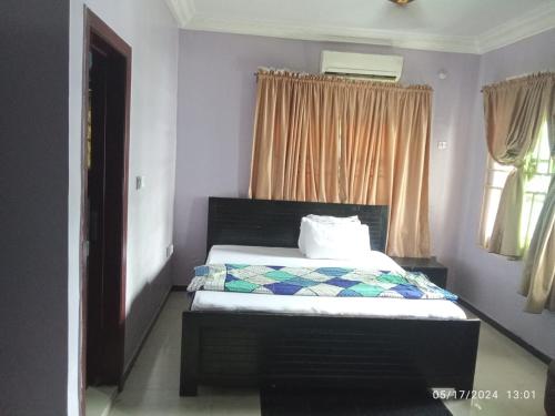 a bedroom with a bed and a window at The Residence in Uyo