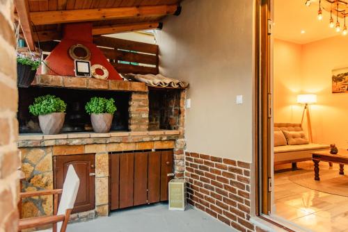 a stone fireplace in a room with a couch and a chair at Kantounata Apartment in Lefkímmi