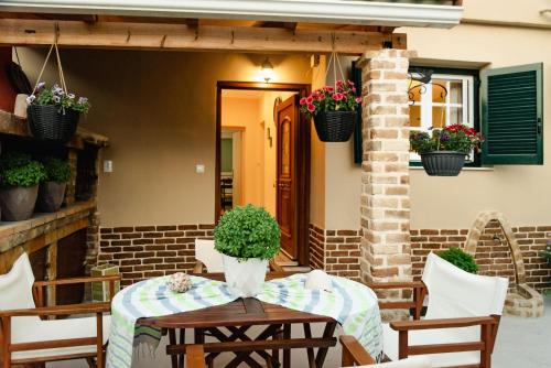 a patio with a table and chairs and potted plants at Kantounata Apartment in Lefkímmi