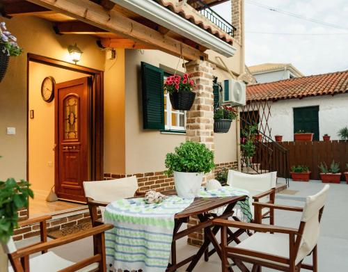a patio with a table and chairs and a house at Kantounata Apartment in Lefkímmi