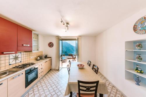 a kitchen with a table and chairs in a room at Eden view Ravello houses - Two bedroom in Ravello