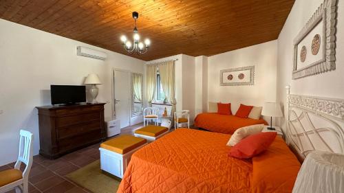 - une chambre avec un lit orange et une télévision dans l'établissement B&B La Terazza Sul Cielo di Maratea, à Maratea