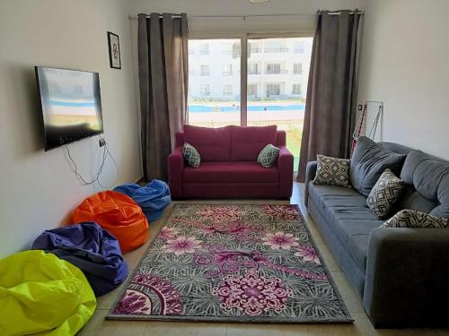 sala de estar con sofá y alfombra en Palmera Beach, en Ain Sokhna