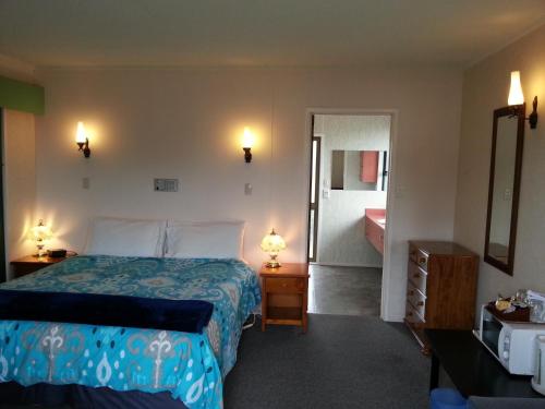 a hotel room with a bed and a bathroom at Orana Motor Inn & Restaurant in Kaitaia
