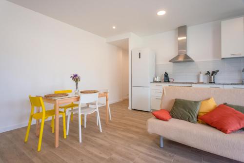 a living room with a couch and a table and chairs at PortBo in Palafrugell