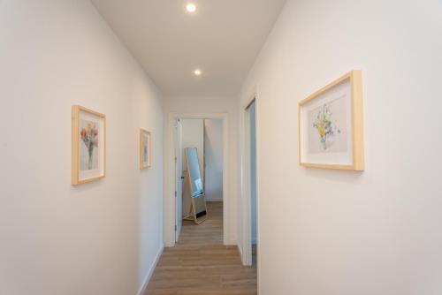 a hallway with three paintings on the walls at PortBo in Palafrugell