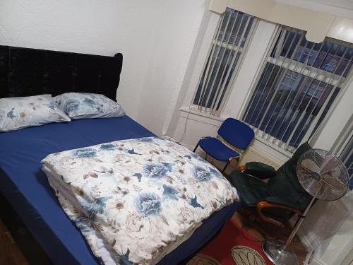 a bedroom with a bed and a fan and two windows at Budgeted Residence near Coventry Building Society (CBS) Arena with Parking in Exhall