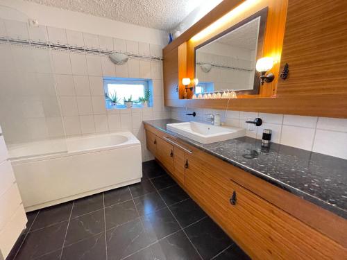 y baño con lavabo, bañera y espejo. en House in Akranes - Birta Rentals, en Akranes
