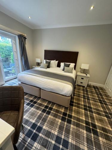 um quarto com uma cama grande e um sofá em The Ryebeck Hotel em Bowness-on-Windermere