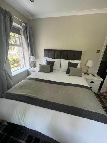 un grande letto bianco in una camera da letto con finestra di The Ryebeck Hotel a Bowness-on-Windermere