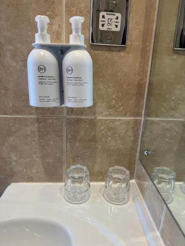 2 botellas de odorizantes en un lavabo del baño en The Ryebeck Hotel, en Bowness-on-Windermere