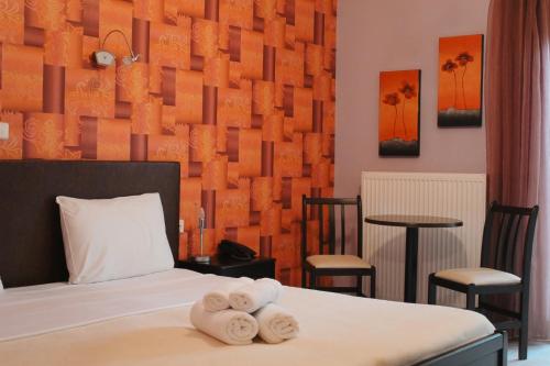 1 dormitorio con 1 cama con toallas en Enastron Hotel, en Kato Loutraki