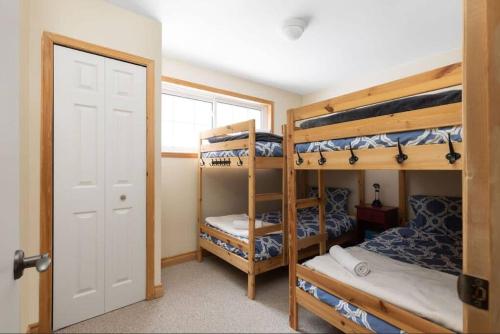 a room with three bunk beds and a door at 3BR Rebecca Lakehouse with Fireplace Wifi and Dock in Oxtongue Lake