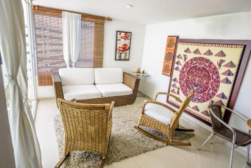 ein Wohnzimmer mit Korbstühlen und einem Sofa in der Unterkunft HomeBeach Conquistador in Cartagena de Indias
