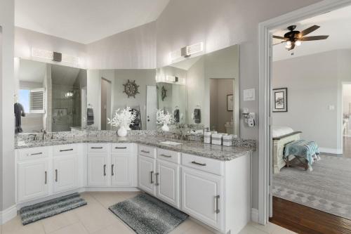 - Baño blanco con 2 lavabos y ducha en Lakefront Family Vacation Home close to Frisco and Dallas, en Little Elm