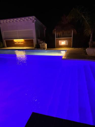 una piscina con iluminación azul por la noche en La Siègià Resort spa, en Massa Marittima