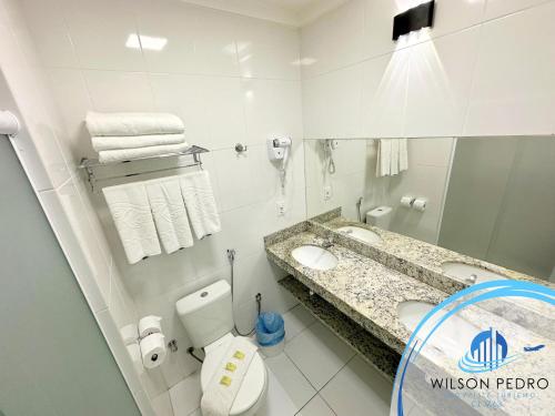 uma casa de banho com um WC, um lavatório e um espelho. em Spazzio diRoma em Caldas Novas