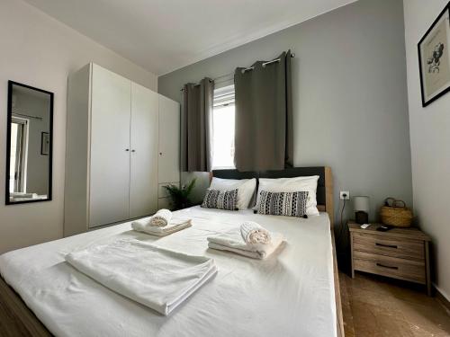 - une chambre avec un grand lit blanc et des serviettes dans l'établissement Brand new apartment, in the heart of Kos '4', à Kos