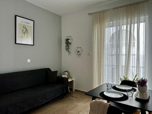 - un salon avec un canapé noir et une table dans l'établissement Brand new apartment, in the heart of Kos '4', à Kos