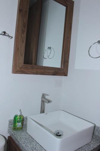 a bathroom with a white sink and a mirror at Hotel Campestre Sueño del Abuelo in Pereira