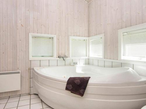 a white tub in a bathroom with two windows at 8 person holiday home in Glesborg in Glesborg