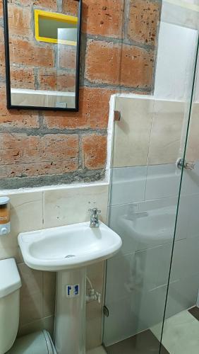 a bathroom with a sink and a mirror and a toilet at Hotel Marrokos Aeropuerto José María Córdova in Rionegro