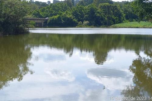 a large lake with trees and clouds in the water at Cabana de pesca e lazer Represa Usina Mafra sc in Mafra
