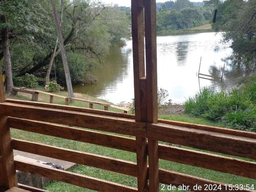a view of a river from a wooden window at Cabana de pesca e lazer Represa Usina Mafra sc in Mafra