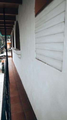a white building with a window and a tiled floor at Hostal Dulces Sueños in Panajachel