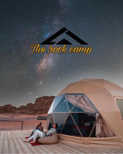 The Rock Camp في وادي رم: شخصان يجلسون في خيمة تحت سماء الليل